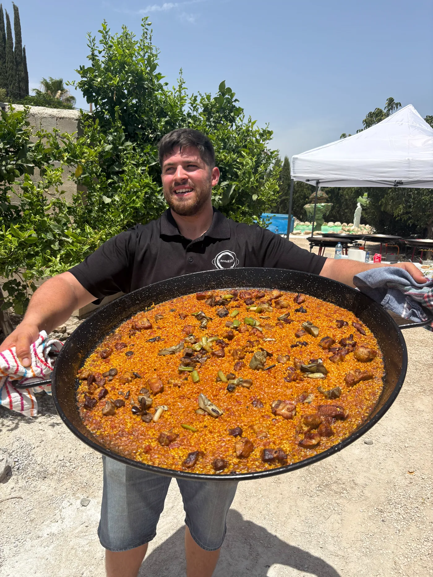 Pedro Guillermo sosteniendo una paella recién hecha