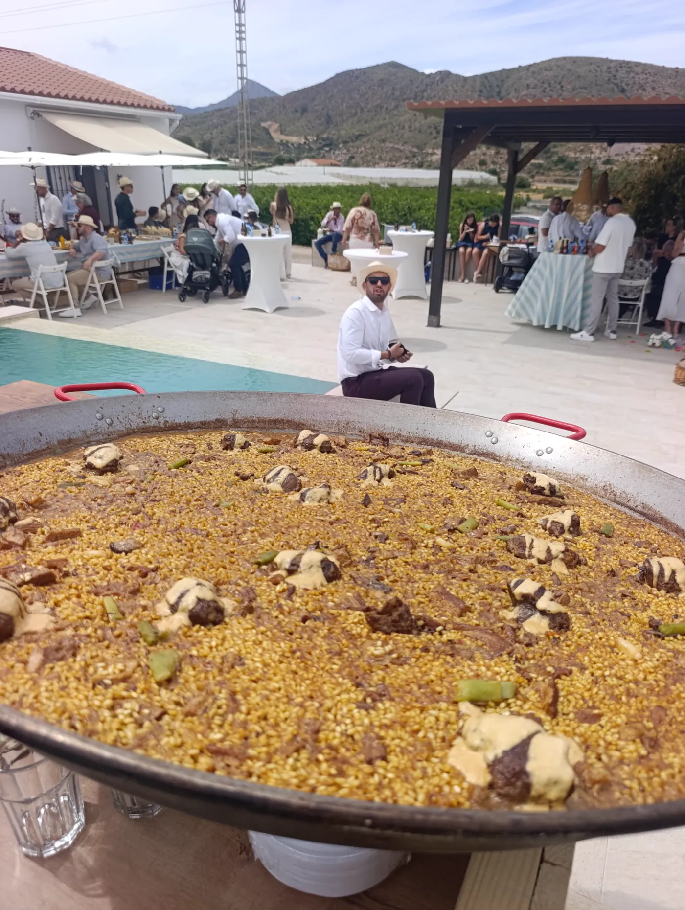 Paella grande terminada en una celebración junto a la piscina