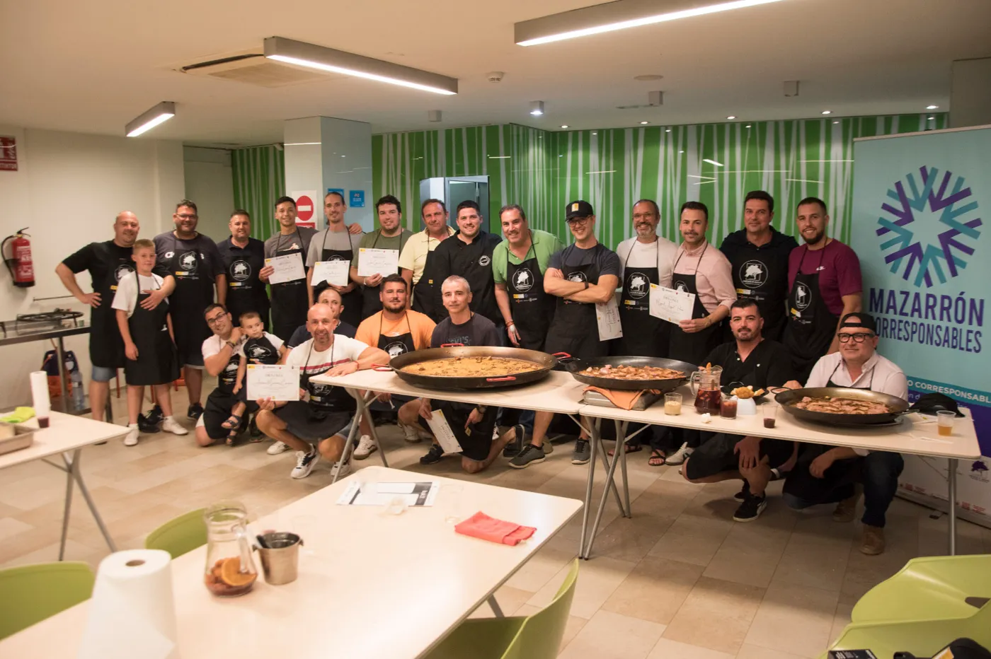 Grupo de alumnos con sus paellas al terminar un taller de arroces
