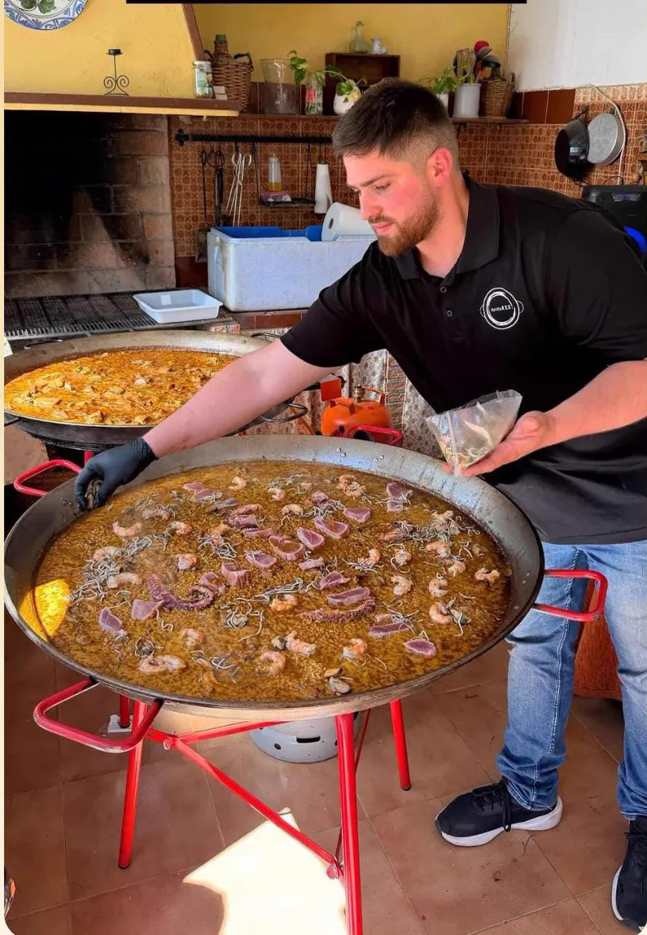 Pedro cocinando una paella en directo delante de los invitados
